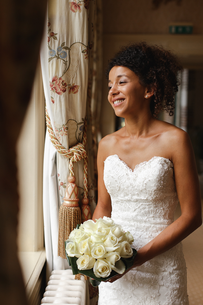 mariee bouquet de roses blanches a la main a la fenetre reportage mariage hauts de france gosnay